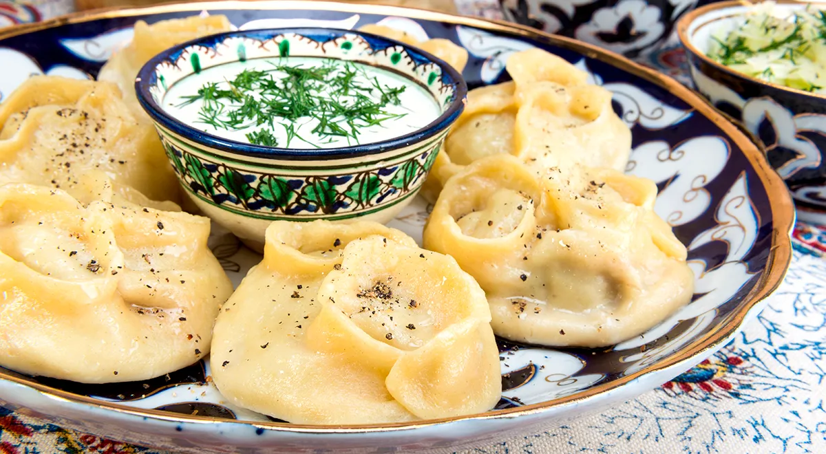 Steamed manti dumplings served with yogurt and fresh dill